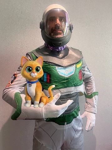 Jorge in a Bizz Lightyear costume holding a toy cat