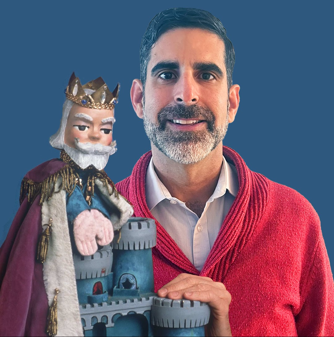 Photo of Jorge holding a puppet with a red sweater